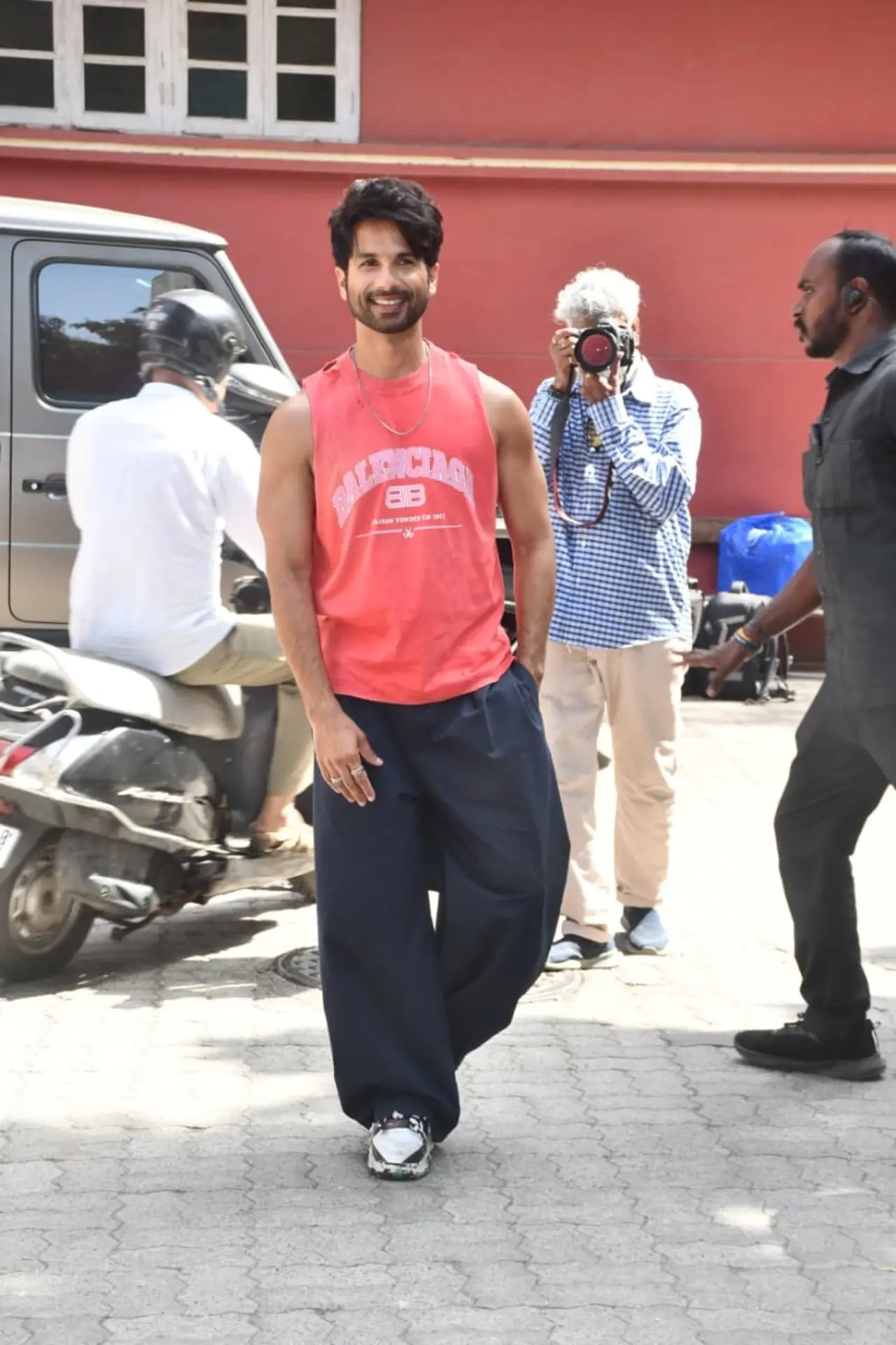 Shahid Kapoor kept it cool and sporty in a sleeveless coral Balenciaga tee paired with oversized navy blue trousers. Shahid Kapoor kept it cool and sporty in a sleeveless coral Balenciaga tee paired with oversized navy blue trousers.